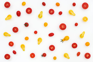 Pattern of red and yellow cherry tomatoes on white