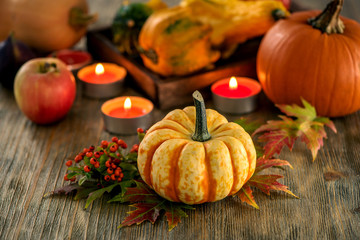 Autumn table setting with pumpkings and candles, fall home decoration for festive dinner