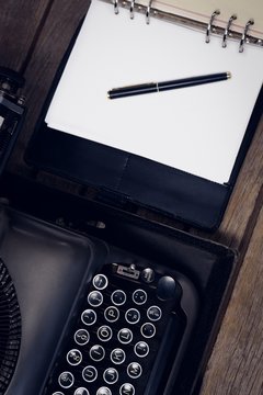 High angle view of typewriter by fountain pen on open diary