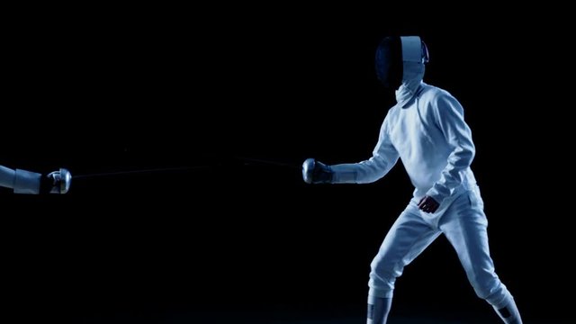 Two Professional Fencers Show Masterful Swordsmanship in their Foil Fight. One Fencer Performs Quick Fleche Attack. Shot Isolated on Black Background  with Cold Tones and Slow Motion.