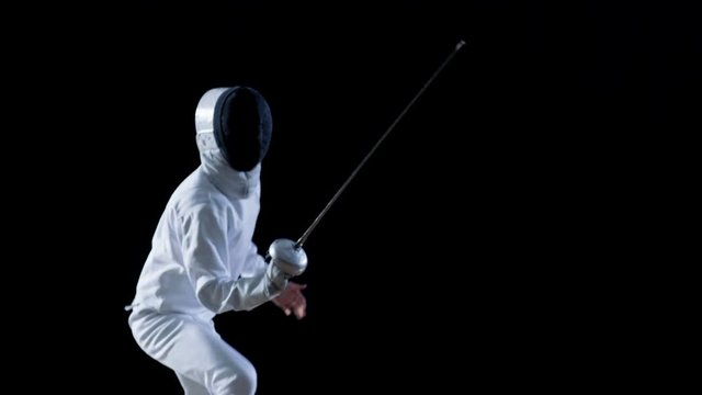 Fully Equipped Skilled Fencer Training with a Foil. He Practices Attack, defense,  Leap, Thrust and Lunge. Shot Isolated on Black Background. Shot on RED EPIC-W 8K Helium Cinema Camera.