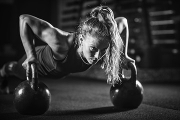 Woman athlete exercising with kettlebell - Powered by Adobe