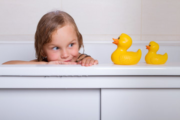 baby girl taking bath with foam and toys