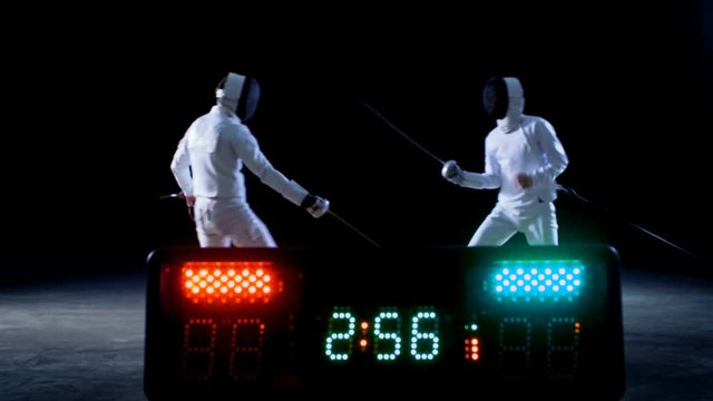 On the Championship Two Professional Fully Equipped Fencers Expertly Fight with Foils while Scoreboard Keeps the Scores of Hits. They Attack, Defend, Leap, Thrust and Lunge.