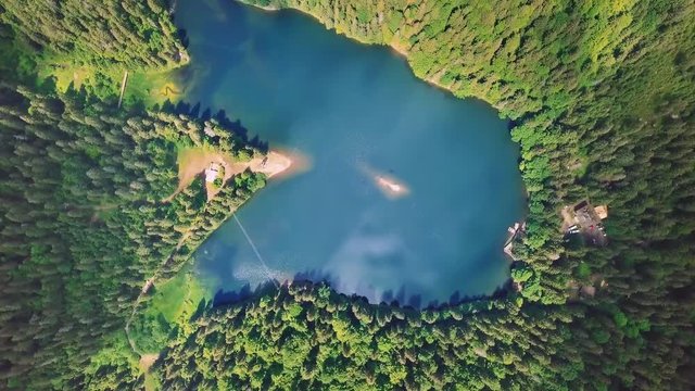 Aerial flythrough of beautiful mountains and forest and lake. Rotation