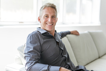 Portrait of single 40s man sitting in sofa