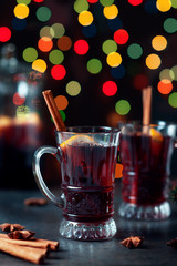 Traditional winter mulled wine in vintage glass and christmas ornament on lights background, selective focus and toned image. Sangria on holiday table. Celebration thanksgiving with spicy cocktail.