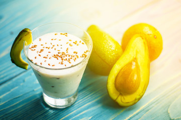 Healthy food. Dietary breakfast or snack. Green smoothies from yoghurt, avocado, oatmeal. On blue wooden table, with ingredients. Selective focus