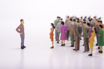 Miniature people in line with boss over white background.