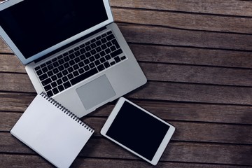 Laptop, digital tablet and diary on wooden table