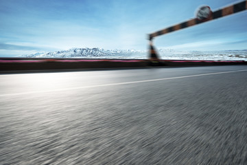 empty asphalt road with snow mountains in blue sky