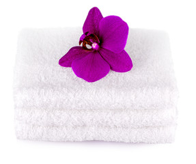 Obraz na płótnie Canvas Stack white spa towels on white background with purple orchid flower.