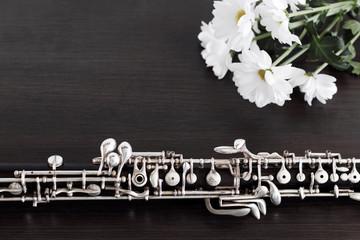 Musical background, poster - oboe on black background with flowers .  Free space for text.