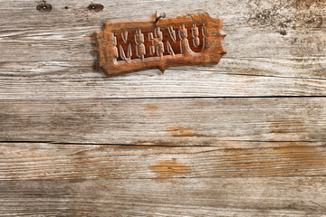 retro style menu sign nailed on aged wooden background