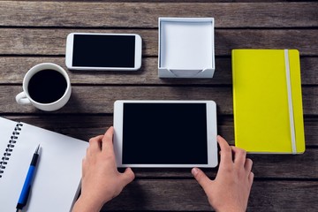 Executive holding digital tablet at desk