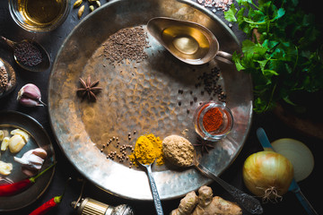 Ingredients for curry paste on the metal plate on the dark background top view
