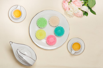 Above of colorful mooncake on dish with tea cup on background