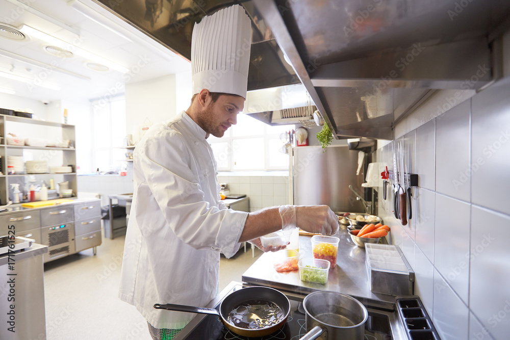 Poster happy male chef cooking food at restaurant kitchen