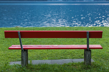 Red bench at lake shore