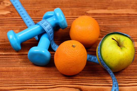 measuring tape, dumbbells weight and apple, orange for diet concept