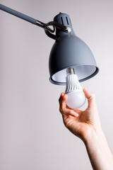 Changing the bulb for led bulb in floor lamp in gray colour.