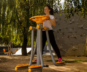 Young girl doing exercises for strengthening legs, outdoor
