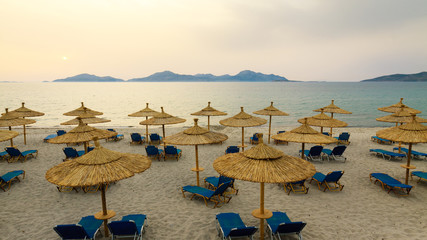 Obraz premium Row sunbeds and umbrellas on beach in morning.