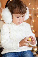Naklejka premium Cute little girl and christmas decor, beautiful light
