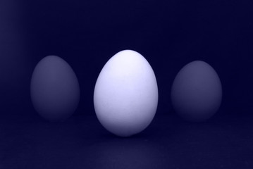 Three eggs on the purple background. Design, visual art, minimalism