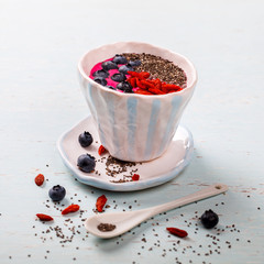 Berry Smoothie in the  bowl.Detox. Breakfast Pudding topped with goji berries, blueberries,  and chia seeds.Concept of Healthy Food.Copy space. selective focus.