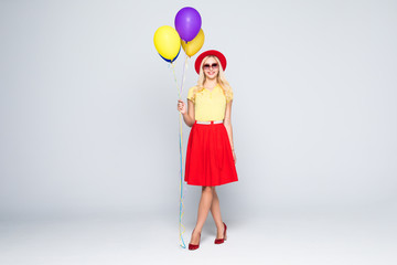 Beautiful woman with colored balloons isolated on gray background