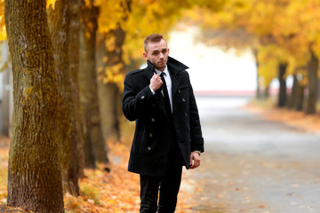 Fashion portrait handsome elegant man in autumn forest. Man's style.