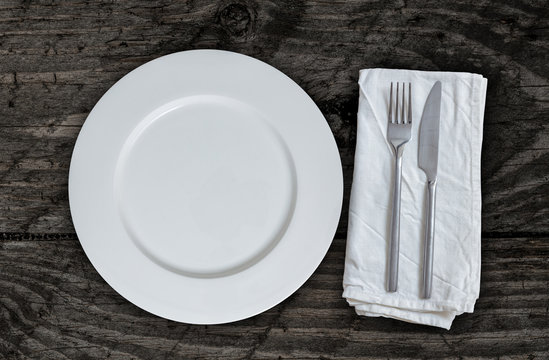 Leerer Teller mit Besteck auf braunem vintage Holz