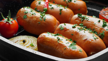 Fried sausages with herbs and vegetables in grill pan