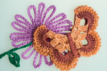 Handmade wool knitted flower and butterfly colorful texture background