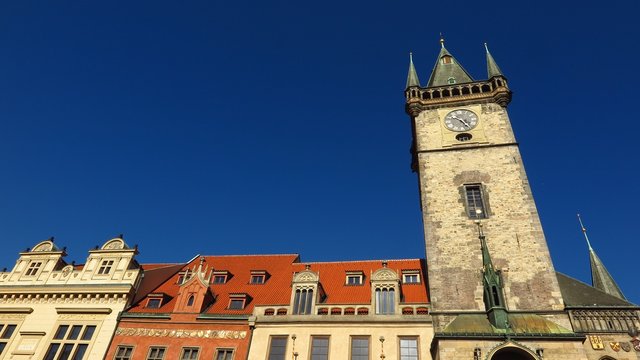 Prague Astronomical Clock tower in Old Town Square with baroque buildings with blue sky
