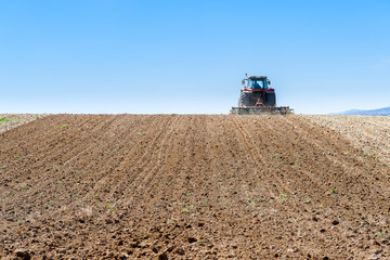 Obraz premium agricultural tractor in the foreground with blue sky background.
