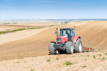 agricultural tractor in the foreground with blue sky background.