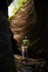 Obraz premium Young adult active man exploring scenic gorge in Uriezzo Italy in sunny summer day outdoor.