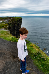 Boy looking out up the Cliffs of Moher Tourist Attraction in Ireland