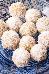 Candy with dates, dried apricots and nuts, vertical, selective focus, top view, hands in frame, ingredients