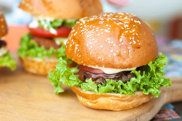Delicious and juicy burger with salad lettuce and pickled cucumber