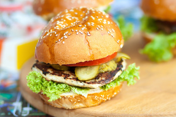 Delicious and juicy burger with salad lettuce and pickled cucumber