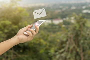 Mobile phone and email in hand with nature background