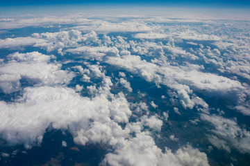 views of clouds and land from airplane window