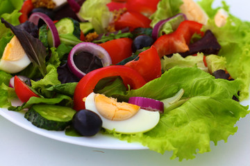 salad from fresh vegetables in a plate on a table, selective focus