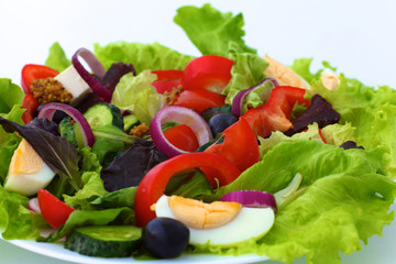 salad from fresh vegetables in a plate on a table, selective focus