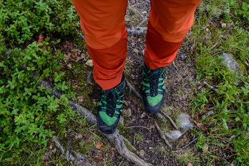 Fototapeta premium Hiker with red pants and green hiking shoes on path