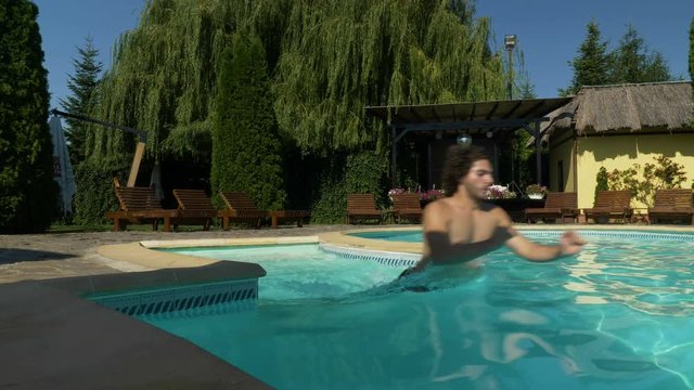 Man goes running into the pool and starts swimming
