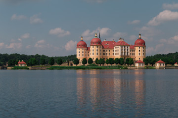 Fototapeta premium Schloss mit rotem Dach und Spiegelung im Wasser